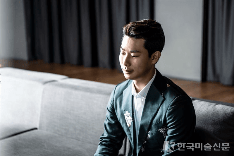 자신이 디자인 한 정장을 입고 있는 김리을 다자이너