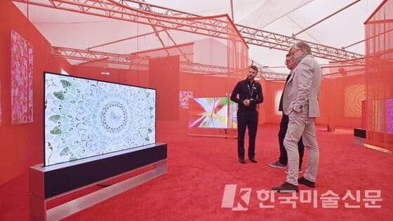 13일부터 영국 런던에서 열린 '프리즈 아트페어' LG 갤러리를 찾은 관람객들이 화면이 말리는 롤러블 올레드 TV인 'LG 시그니처 올레드 R'로 데미안 허스트의 예술 작품을 감상하고 있다. (출처 = LG전자)