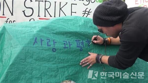 정재철 작가는 여행과 예술, 일상이 하나로 통하는 사회참여적이고, 수행적인 작업 세계를 펼쳤다. 영국 런던 팔러먼트 광장의 반전 시위대 천막에 한글로 사랑과 평화를 적는 행위는 &lsquo;실크로드 프로젝트&rsquo;로 진행됐다.아르코미술관 제공