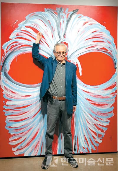 화면을 등진 채 선을 그은 `신체의 풍경 76-2` 연작 앞에서 팔을 뻗은 이건용 작가.