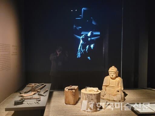 전시장 2부 &lsquo;불상과 불화를 만든 공간&rsquo;의 들머리에 펼쳐진 &lsquo;어느 조각승의 스튜디오&rsquo; 재현 공간. 대패, 자귀, 도끼, 망치 등 작업도구와 제작 중인 불상 등을 볼 수 있다.