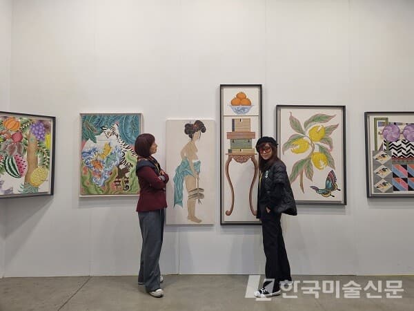 레지나 갤러리 부스에서 포즈를 취한 현대민화 이경숙 작가(왼쪽)와 이소영 작가 (사진=이미희 미술전문기자)