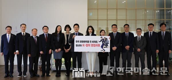 김건희 여사가 15일 열린 재외문화원장 및 문화홍보관과의 오찬에서 &lsquo;K-컬처 영업사원&rsquo; 웹툰 캐릭터가 그려진 팻말을 들고 기념사진을 촬영하고 있다.