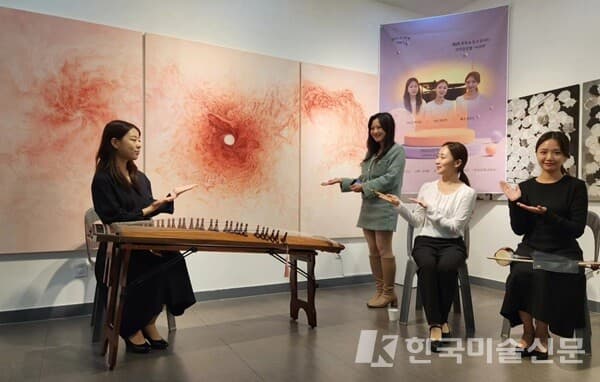 아라연 콘서트에 참석한 유민지 작가(오른쪽에서 세 번째)가 자신의 작품 '의식'을 연주자들과 함께 가리키면서 기념촬영을 하고 있다.(사진=허영훈 기자)