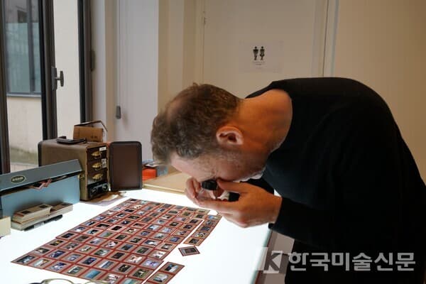 리 슐만은 슬라이드를 자세히 본 후, 전시할 사진을 골라낸다. 이소이 기자