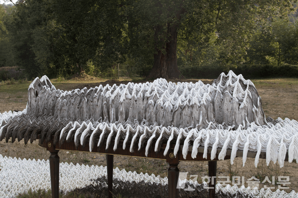 Paysage scénique, Le Banquet et le travail du temps, sucre, plâtre, mobilier, 300x700x150 cm, 2022. Abbaye de l'Escaladieu, &copy; Hugo BEL / '연극적 풍경, 의자와 시간의 작용'이라는 작업으로 위의 '연극적 풍경, 의자' 작업이 시간의 영향으로 변형된 상태의 작업이다.