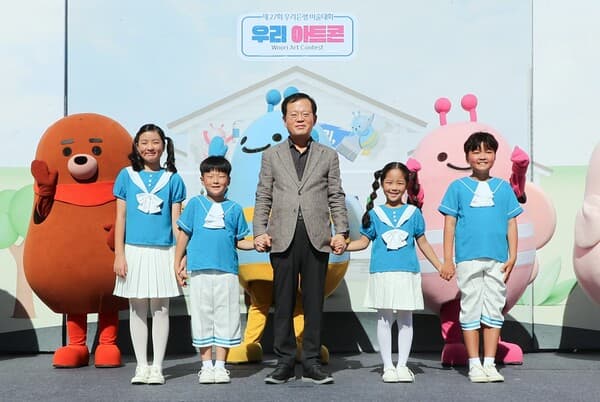 우리은행 조병규 은행장이 지난 29일 마포 문화비축기지에서 열린 제27회 우리은행 우리미술대회 '우리아트콘'의 축하공연을 진행한 다문화어린이합창단 단원들과 기념사진을 촬영하고 있다. [사진=우리은행]