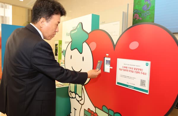 함영주 하나금융그룹 회장이 카드결제 방식으로 기부할 수 있는 '기부 키오스크'를 통해 발달장애 예술가들에게 따뜻한 마음을 전달하고 있다. [사진=하나금융그룹]