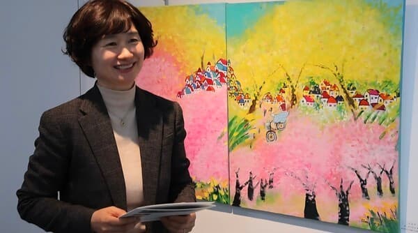 13일 김성아 작가는 네가있어 빛나는 봄날 작품앞에서 그림속의 여인에 대해 설명을 하고 있다. [사진=차윤기 기자]