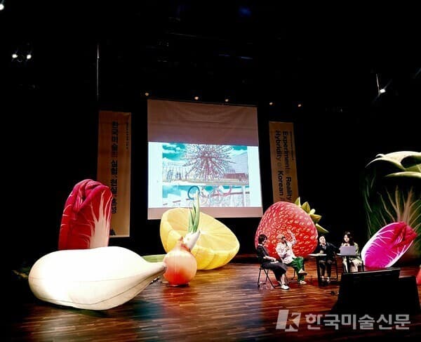 MMCA 아카데미 시즌 2 - 7강 「예술은 없다, 당신이 예술이다」 강연 전경. 무대 위 대형 인플레이터블 과일&middot;채소 설치물이 가득하다. 2026. 6. 17. 국립현대미술관 서울 다원공간. ⓒ엄미영 미술전문기자